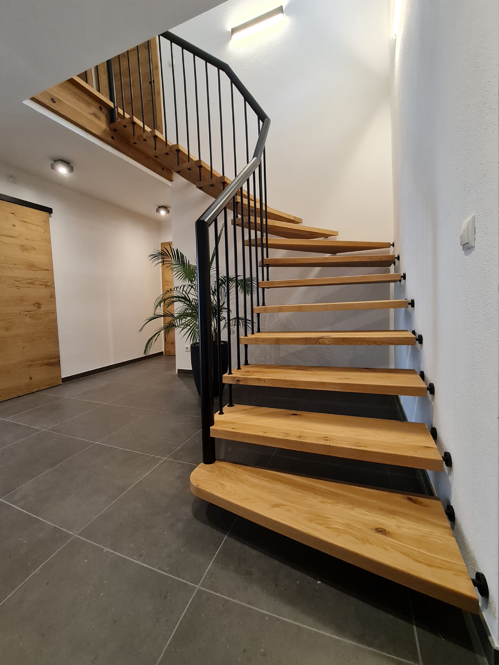 Escalier suspendu bois rampe métallique à balustres inox en noir