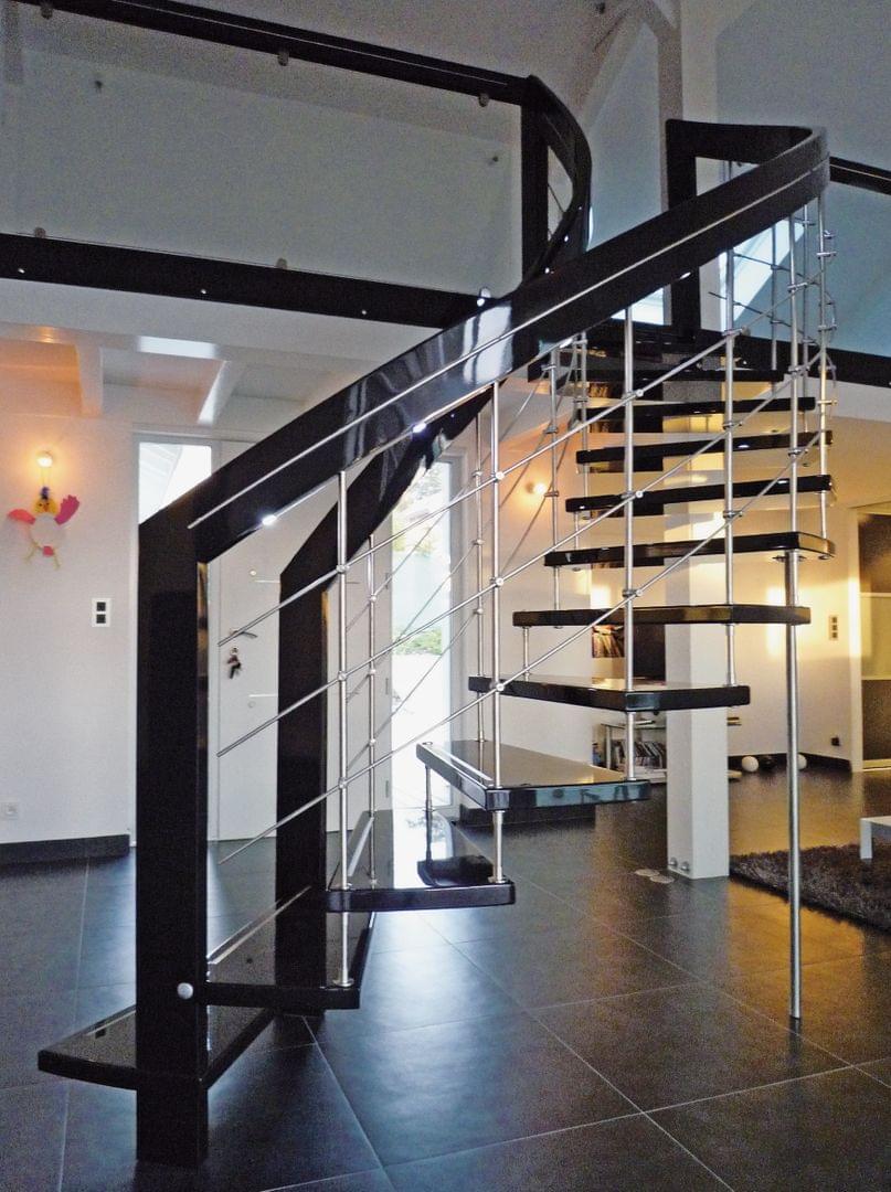 Escalier en colimaçon marches en bois teinté noir garde-corps en metal design Treppenmeister